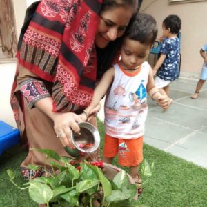 kid watering plant with teacher kindergarten mumslap.in