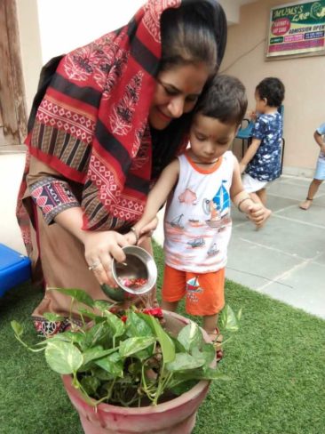 kid watering plant with teacher kindergarten mumslap.in